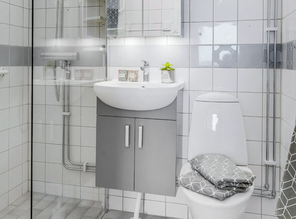 Kakel och väggar i badrum målade i ljus ton – projekt av Malmö Måleri i Kulladal.